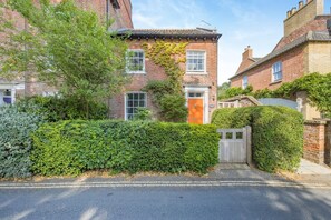 A residential property with a brick facade, a wooden gate, and a well-maintained hedge. - 2 Bed in Wells-next-the-Sea (oc-c29565) (Wells-next-the-Sea)