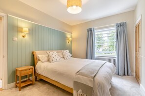 A bedroom with a bed, bedside table, lamp, window, and curtains. - 2 Bed in Wells-next-the-Sea (oc-c29565) (Wells-next-the-Sea)