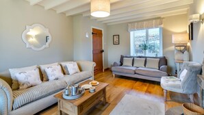 A cozy living room with two sofas, a coffee table, and a fireplace. - 3 Bed in Horsehouse (oc-e29610) (Horsehouse)
