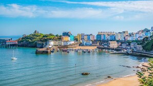 A coastal town with colorful buildings, a harbor with boats, and a sandy beach. - 3 Bed in Tenby (oc-m29588) (Tenby)
