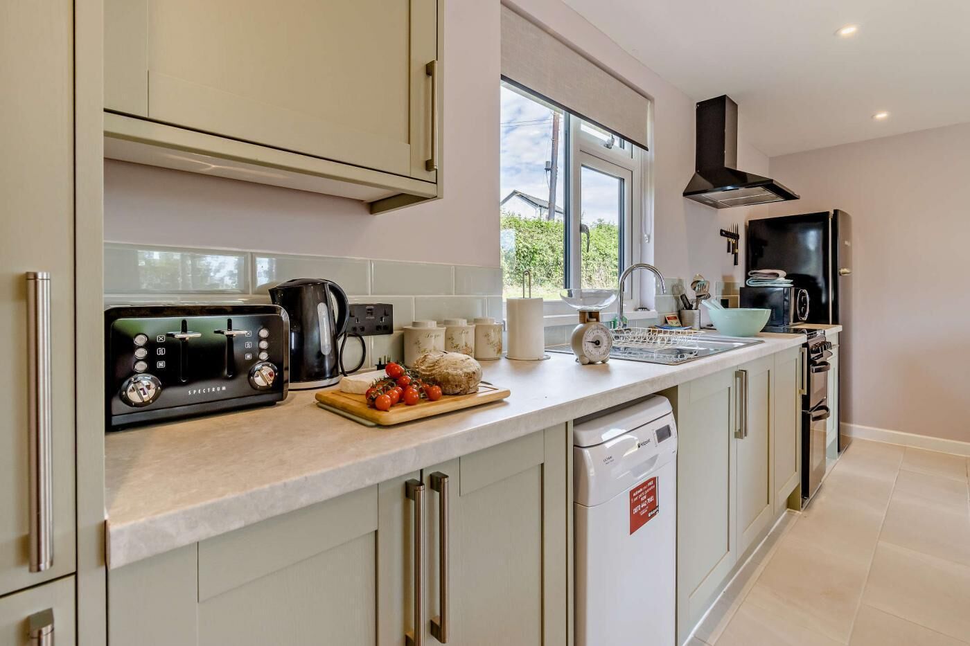 Een oven, een vaatwasser, een kinderstoel, kookgerei, borden en bestek