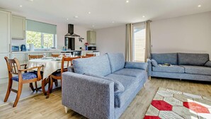 Un salon moderne avec un canapé gris, une table à manger en bois et des chaises.