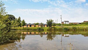 Un cadre paisible au bord d’un lac, avec des bâtiments modernes, un ciel dégagé et une étendue d’eau calme qui reflète l’environnement.