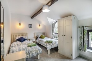 A bedroom with two beds, a wardrobe, and a window with curtains. - 3 Bed in Earl Sterndale (oc-h29624) (Earl Sterndale)