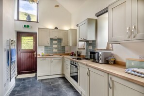A modern kitchen with a built-in oven, a stainless steel sink, and light-colored cabinetry. - 3 Bed in Earl Sterndale (oc-h29624) (Earl Sterndale)