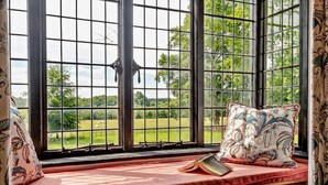 A window seat with a red cushion, a book, and a patterned pillow. - 1 Bed in Tollard Royal (oc-l29639) (Tollard Royal)