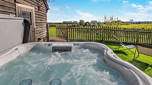 A hot tub with two glasses, a wooden house, and a fenced garden. - 1 Bed in Stone (oc-t29685) (Stone in Oxney)