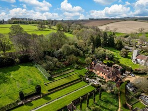 Un vaste domaine comprenant un jardin à la française, une maison principale et une église.