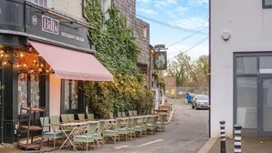 An outdoor cafe with tables and chairs, a restaurant sign, and a tavern sign. - 1 Bed in Lewes (oc-n29713) (Lewes)