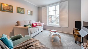 A living room with a sofa, a coffee table, and a TV. There are three framed pictures on the wall. - 1 Bed in Lewes (oc-n29713) (Lewes)