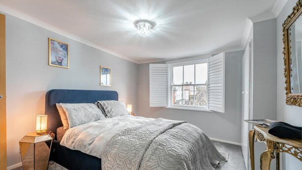 A bedroom with a bed, bedside lamps, a window, and a mirror. - 1 Bed in Lewes (oc-n29713) (Lewes)