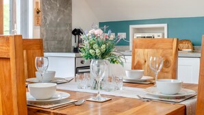 A dining table set with white bowls, wine glasses, and a vase of flowers. - 1 Bed in Abbeydore (oc-l29485) (Abbey Dore)