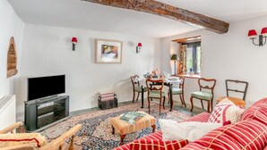 Een gezellige woonkamer met een open haard, een eethoek en een televisie.