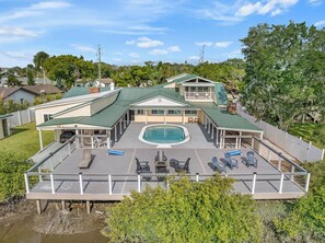A large house with a swimming pool, covered patio, and multiple decks.