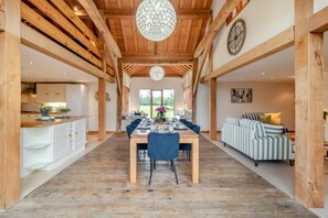 Ein geräumiger Essbereich mit einem langen Holztisch, blauen Stühlen und einer Kristallleuchter.
