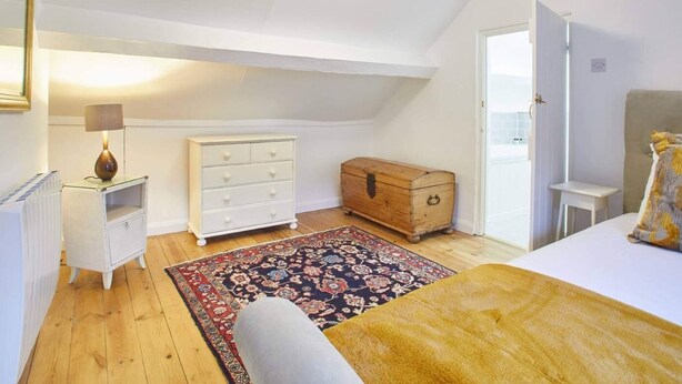 A bedroom with a bed, a dresser, a chest of drawers, a lamp, and a rug. - 3 Bed in Staithes (oc-g29738) (Staithes)
