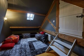 A loft bedroom with exposed wooden beams, a sloped ceiling, and a skylight. - 4 Bed in Egton (oc-a29734) (Egton)