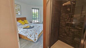 Quarto com cama, mesa de cabeceira e janela.