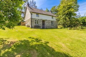 A stone house with a sloped roof and a small front porch. - 3 Bed in Llwynygroes (oc-t29715) (Llangeitho)
