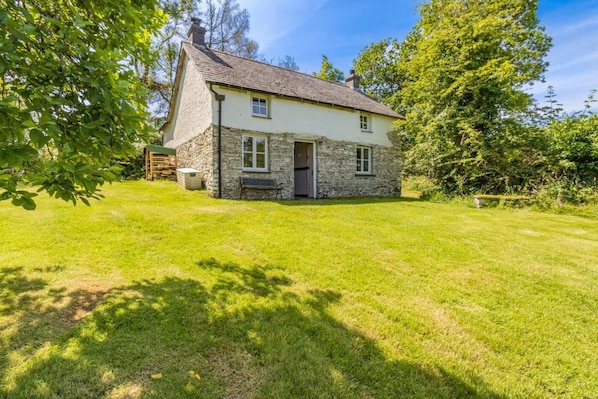 A stone house with a sloped roof and a small front porch.