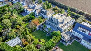 Vue aérienne d’un quartier résidentiel avec de nombreuses maisons, une pelouse bien entretenue et une végétation luxuriante tout autour.