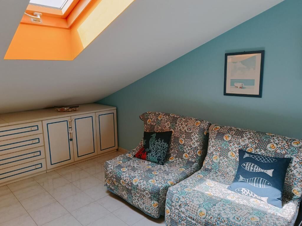 A cozy room with a patterned sofa, a cabinet, and a framed picture on the wall.