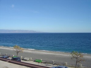 A coastal road with a beach, a clear sky, and a distant mountain range. - Myron Apartment SEA FRONT beachfront house (Roccalumera)