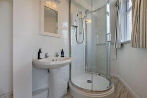 A bathroom with a glass-enclosed shower, a pedestal sink, and a mirror. - 1 Bed in St. Ives (oc-p29852) (St Ives)