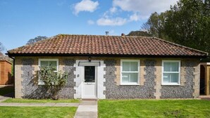 A single-story house with a tiled roof, a front door, and two windows. - 1 Bed in Northrepps (oc-m29800) (Crossdale Street)
