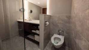 A modern bathroom with a glass shower enclosure, a toilet, and a vanity with a mirror and towel rack. - Executive King Room with with Modern Amenities & Breakfast (Hillsdale)