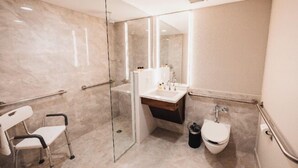 Ein modernes Badezimmer mit Duschkabine aus Glas, einem weißen Waschbecken und einer Toilette.