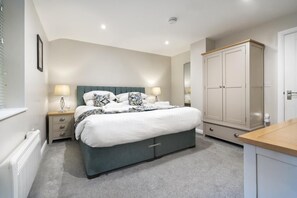 A bedroom with a bed, bedside tables, a wardrobe, and a radiator. - 3 Bed in Newby Bridge (oc-c29820) (Newby Bridge)