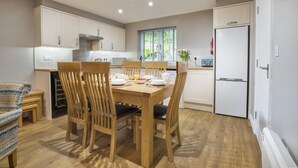 Una cocina moderna con sillas de madera, una mesa de comedor y un horno empotrado.