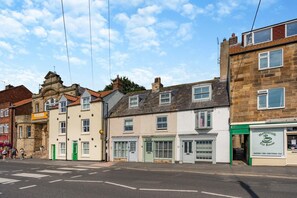 A street view with buildings, including a tea room with a green sign. - 2 Bed in Whitby (oc-w29863) (Whitby)