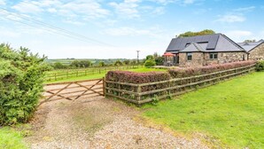 A stone house with a gravel driveway and a wooden gate. - 2 Bed in Reynoldston (oc-l29892) (Reynoldston)