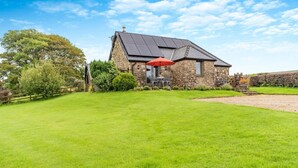 A stone house with a sloped roof and a red umbrella. - 2 Bed in Reynoldston (oc-l29892) (Reynoldston)