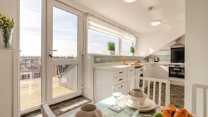 A modern kitchen with a dining area, large windows, and a view of the city. - 2 Bed in Bridlington (oc-o29897) (Bridlington)