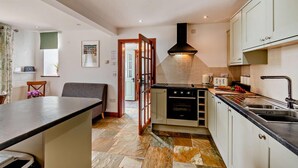 A modern kitchen with a central island, built-in oven, and a large window. - 2 Bed in Loveston (oc-l29792) (Reynalton)