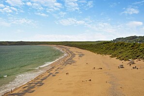 A wide sandy beach with a clear view of the ocean and a hilly landscape in the background. - 4 Bed in St. Florence (oc-r29795) (Saint Florence)