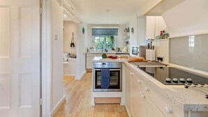 A modern kitchen with a central island, built-in oven, and ample counter space. - 3 Bed in Docking (oc-g29874) (Docking)