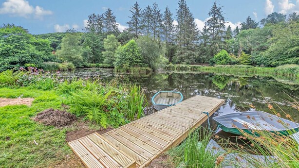 A wooden dock extending into a calm river surrounded by lush greenery and trees. - 3 Bed in Two Waters Foot (oc-l29857) (Broadoak)