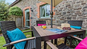 Un patio al aire libre con una mesa, sillas y una lámpara de mesa.