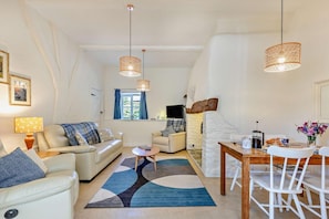 A modern living room with a sofa, coffee table, and dining area.