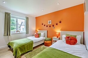 A room with two beds, a window with curtains, a radiator, and a wall with a garland. - 2 Bed in Langtree (oc-e29913) (Langtree)
