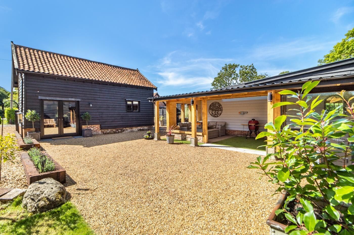 A building with a tiled roof and a covered patio area with outdoor seating.