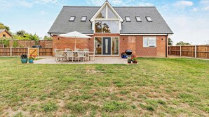 A house with a brick exterior, a sloped roof, and a front porch with a table and chairs. - 4 Bed in Cawston (oc-p29906) (Cawston)