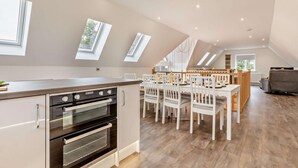 A modern kitchen with a dining area, featuring skylights and a loft-style ceiling. - 4 Bed in Cawston (oc-p29906) (Cawston)
