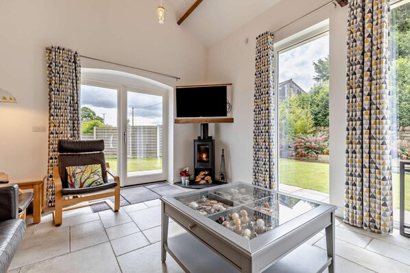 A modern living room with a fireplace, a glass coffee table, and a comfortable seating area.