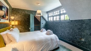 A bedroom with a large bed, a green headboard, a skylight, and a view of the outdoors. - 3 Bed in Thelwall (oc-c29954) (Warrington)