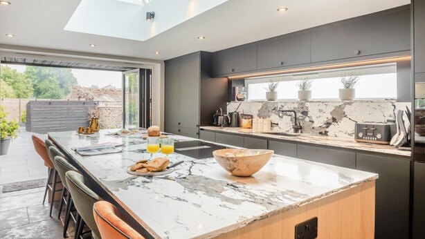 A modern kitchen with a large island, a skylight, and a view of the outdoors. - 4 Bed in Helmsley (oc-l29736) (Helmsley)